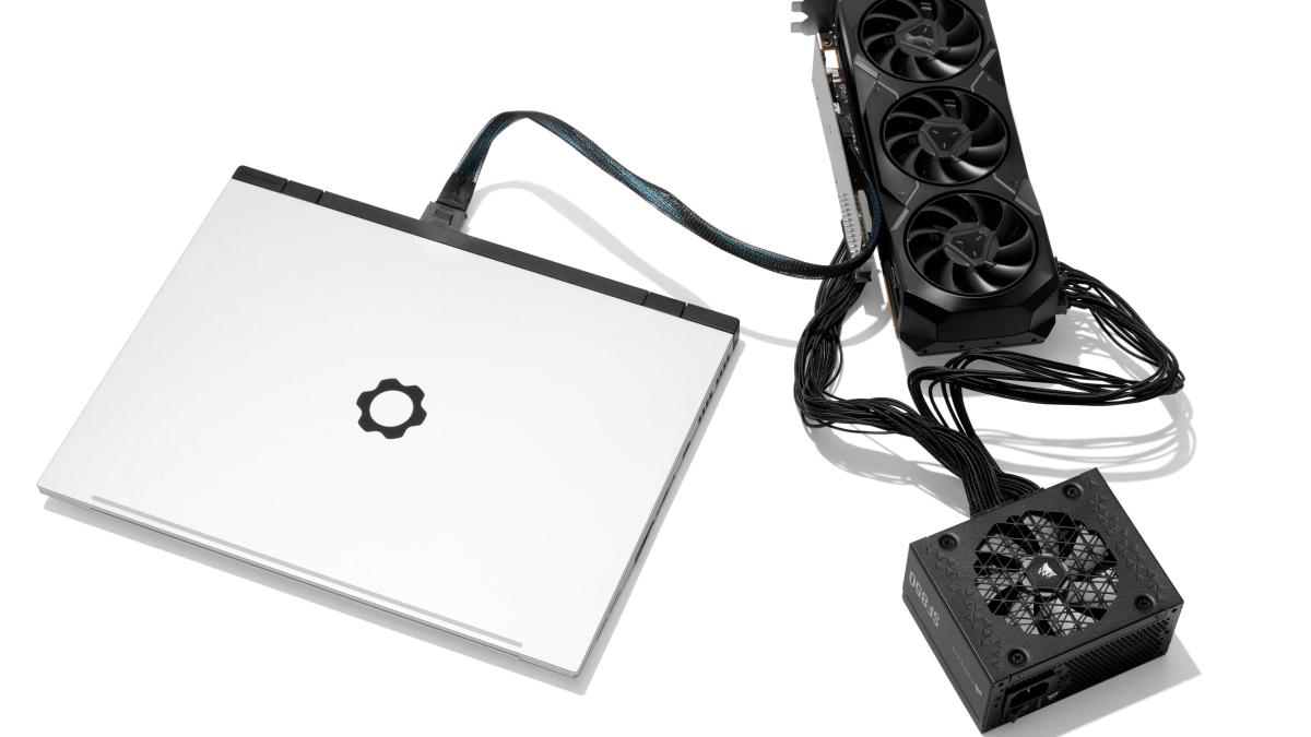 A white Framework Laptop 16 is connected to an external GPU through the OCuLink Dev Kit.