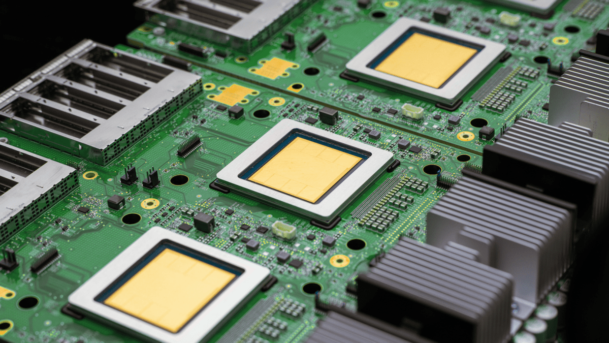 A green computer board with a row of four yellow computer chips
