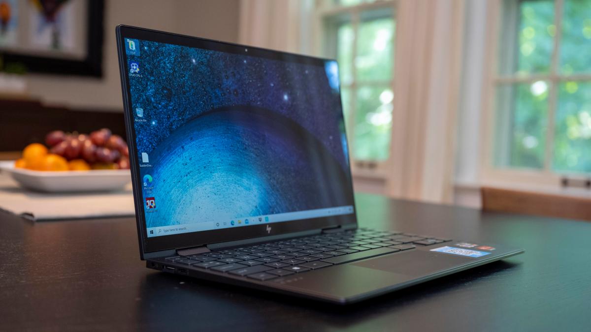 The HP Envy x360 13 from 2020 on a kitchen table with fruit and physical windows in the background