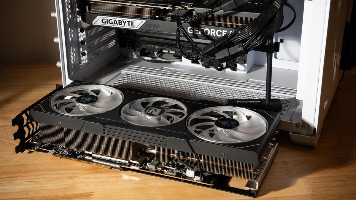 A computer graphics card sitting next to an open PC case.