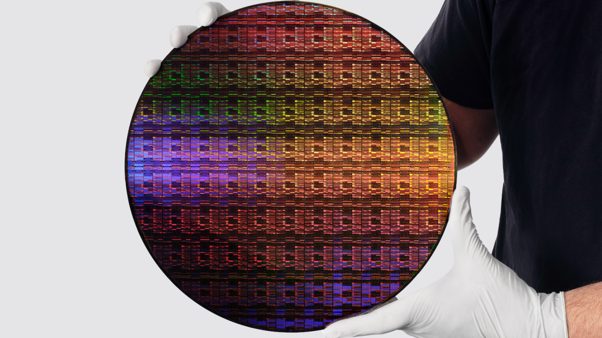 A researcher wearing white gloves and holding IBM's sub-1nm node wafer