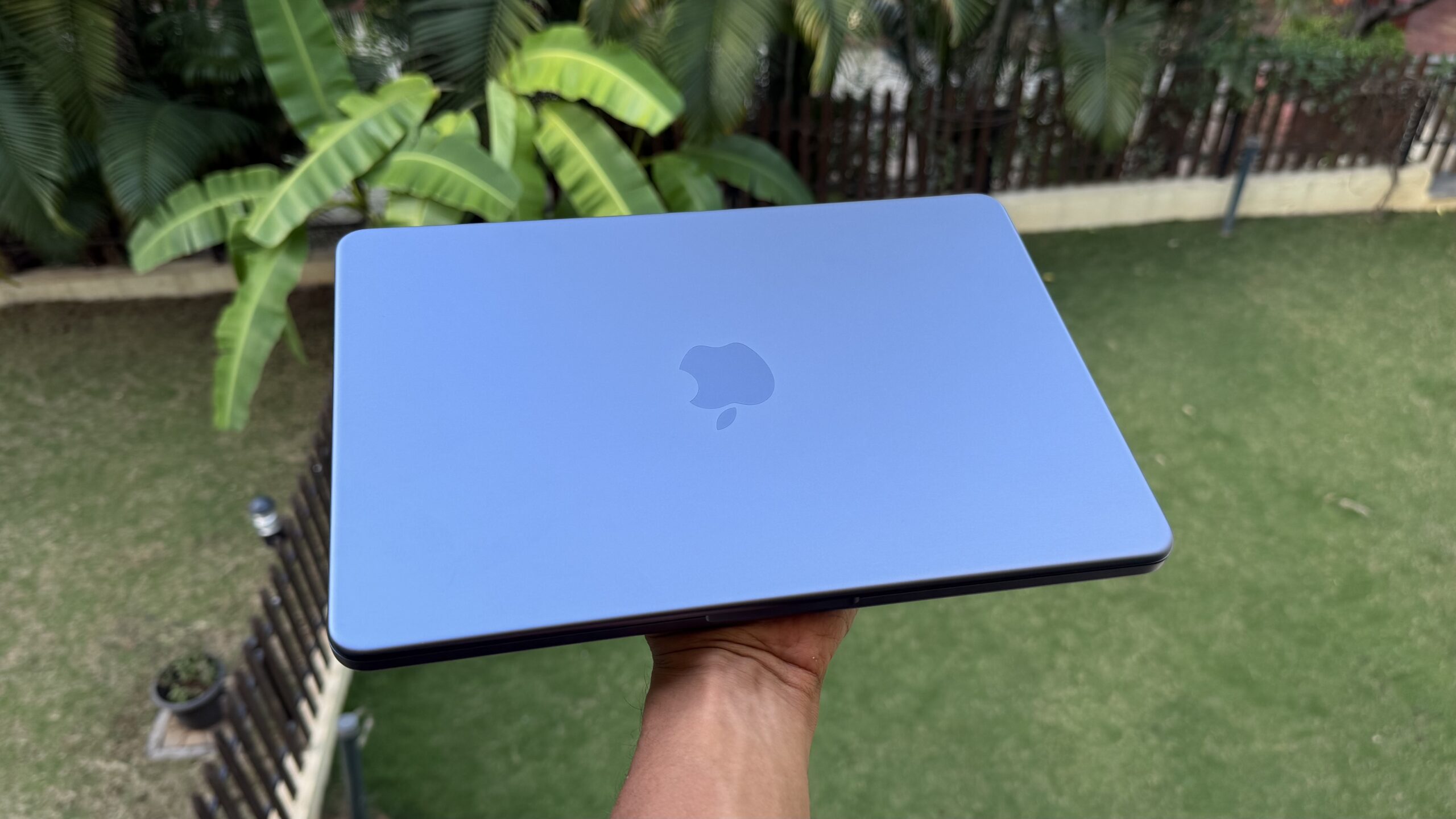Pessoa segurando o MacBook Neo na cor Indigo