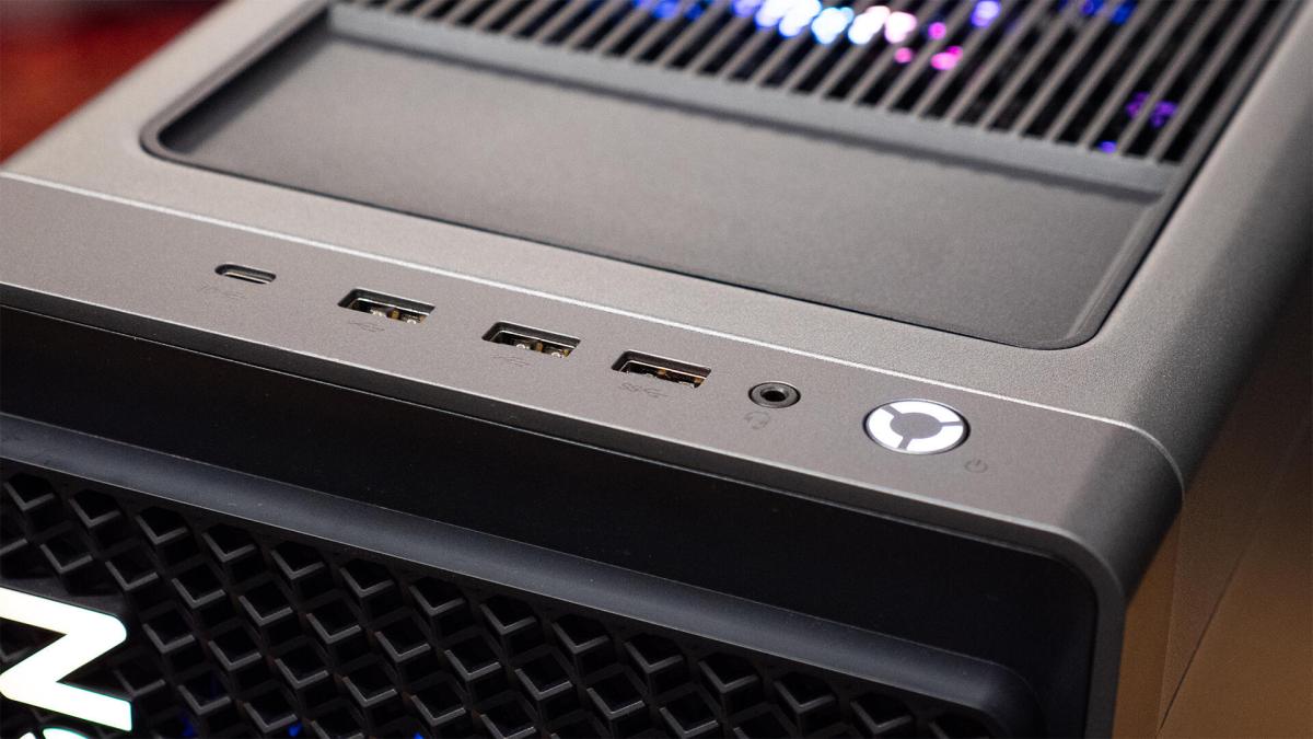 A parte superior de um computador mostrando portas USB e o botão de liga/desliga.