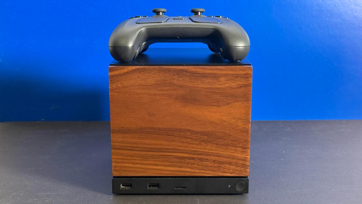 Valve Steam Machine com painel frontal em textura de madeira e Steam Controller em cima